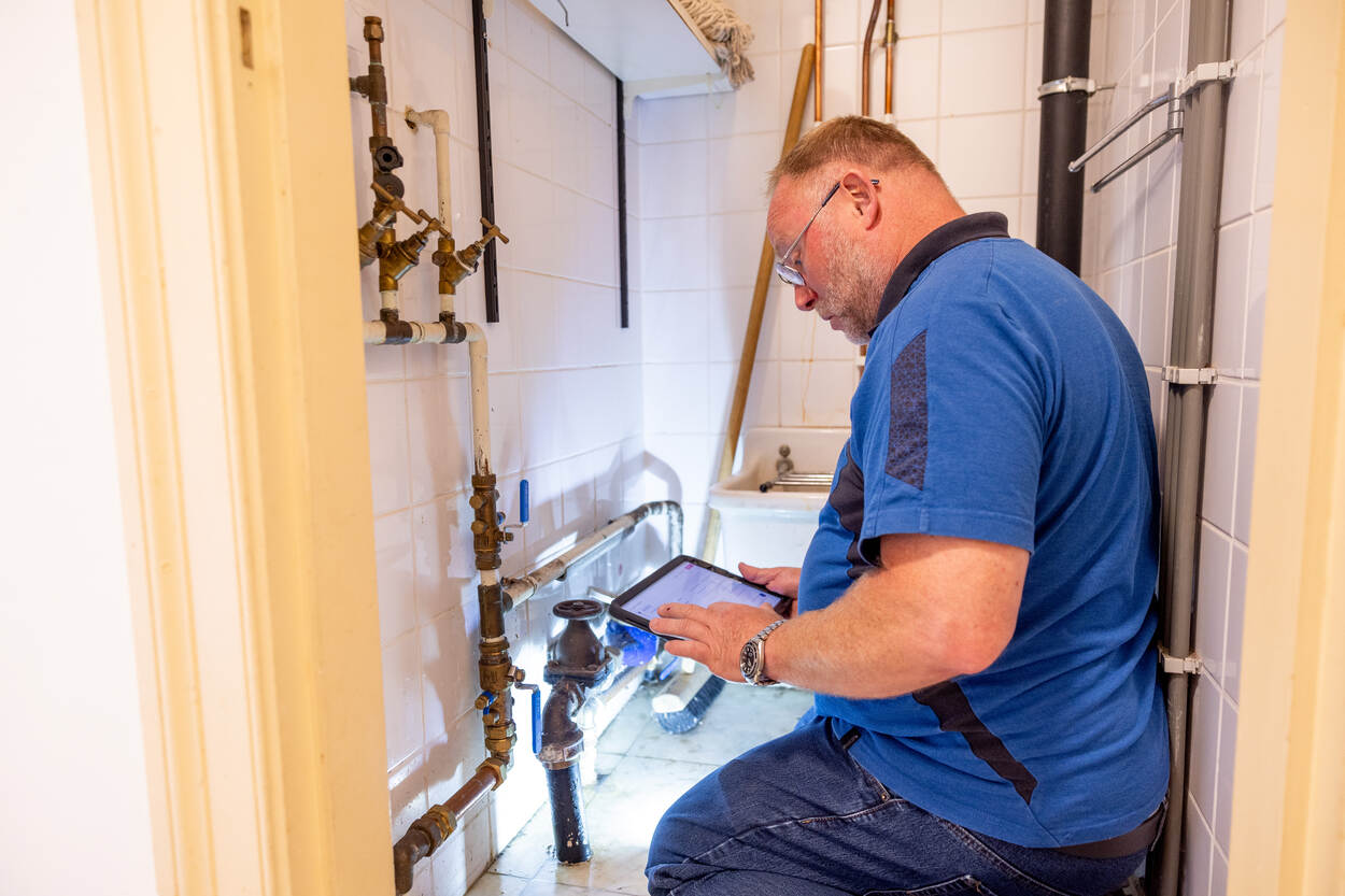 Een inspecteur bekijkt de drinkwaterinstallatie van Huis Doorn.