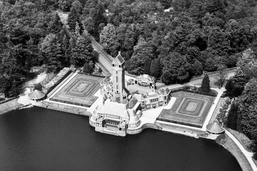 Zwart-wit luchtfoto van Jachthuis Sint Hubertus op de Hoge Veluwe.